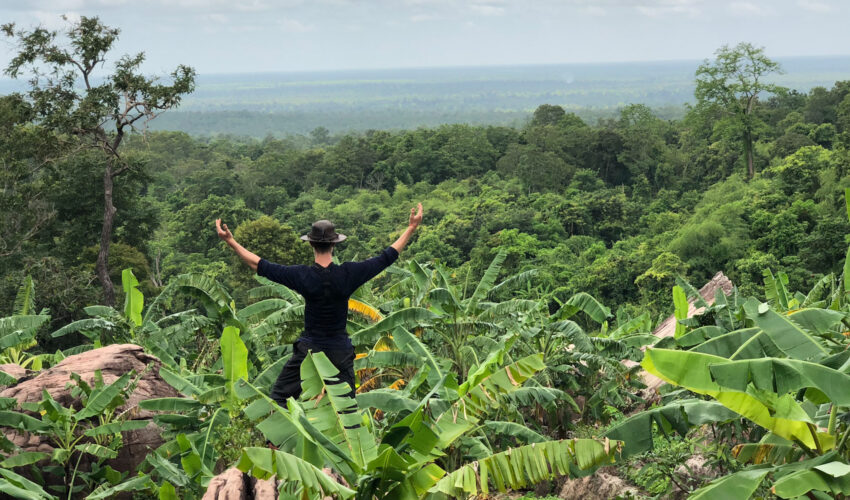 A traveller enjoying beautiful views on a trek in Cambodia