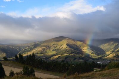 Ecuador mountain top with lots of clouds and a rainbow