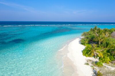 Crystal blue waters, white beach and luscious green palm trees of the Maldives.