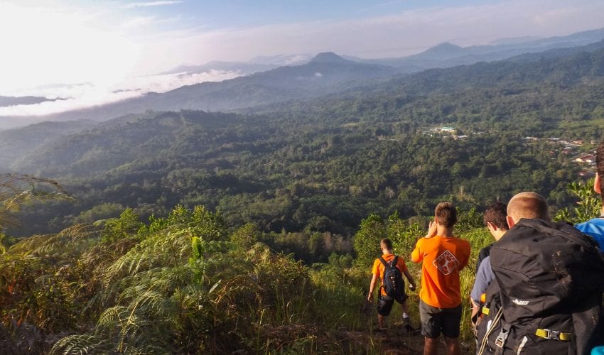 School Expedition in Borneo. Travellers walking with a beautiful landscape ahead of them