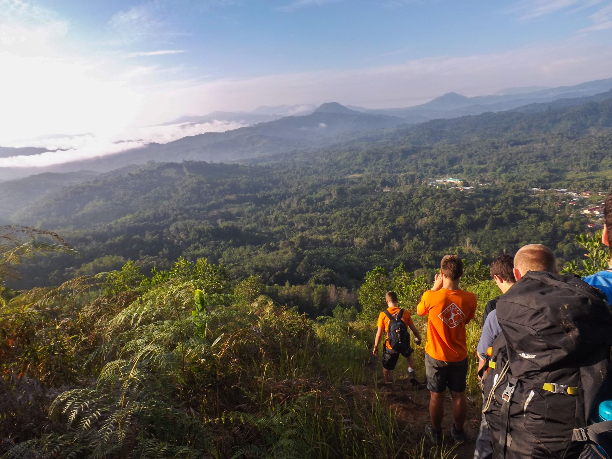 School Expedition in Borneo. Travellers walking with a beautiful landscape ahead of them
