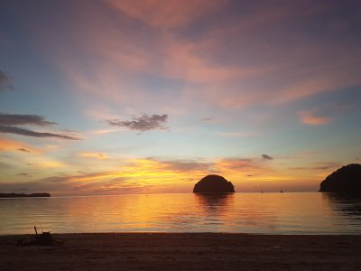sunset over the sea in Borneo with hues of oranges, pinks, purples and blues