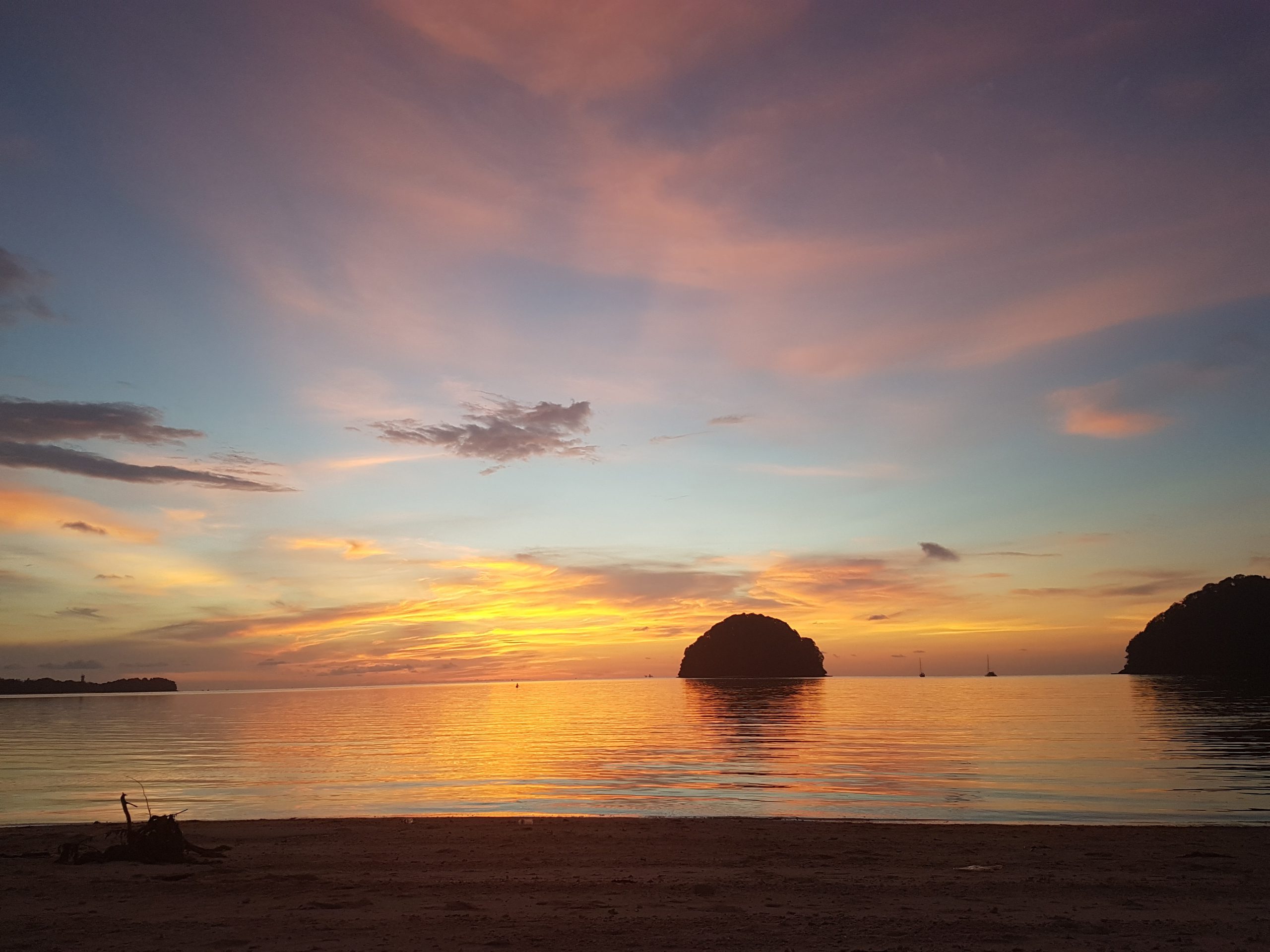 sunset over the sea in Borneo with hues of oranges, pinks, purples and blues
