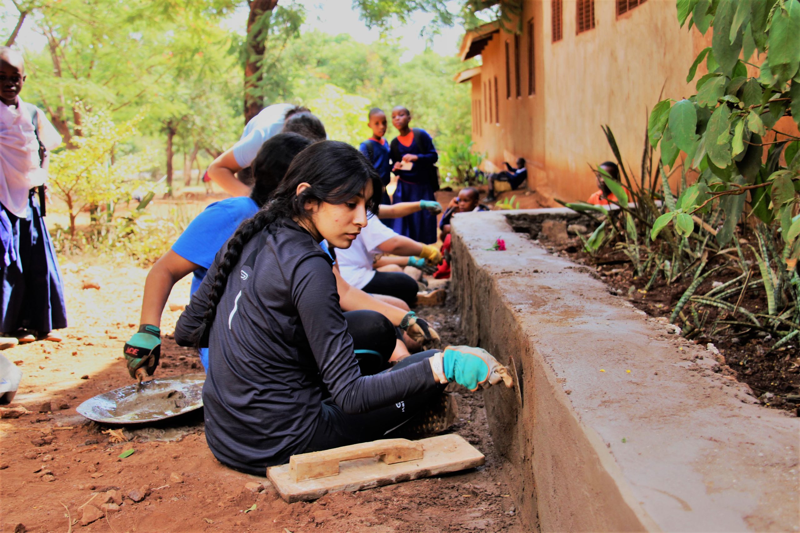school_expedition_tanzania_trek_plastering_wall