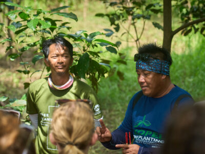 Locals in Ecuador showing student travellers how to plant trees and regenerate the land