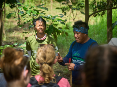 Locals in Ecuador showing student travellers how to plant trees and regenerate the land