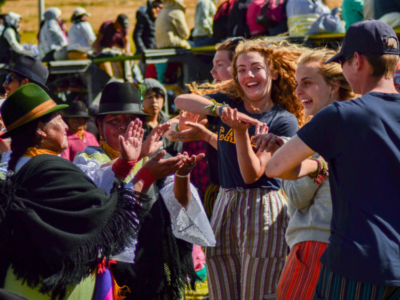 A group of Camps International students dancing with local Peruvian people at a cultural exchange in the local village